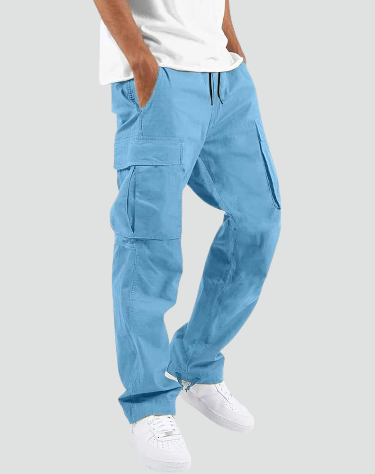 Model trägt die Cargohose in Hellblau mit Kordelzug und großen Seitentaschen, dazu weißes T-Shirt und weiße Sneaker vor grauem Hintergrund. 14