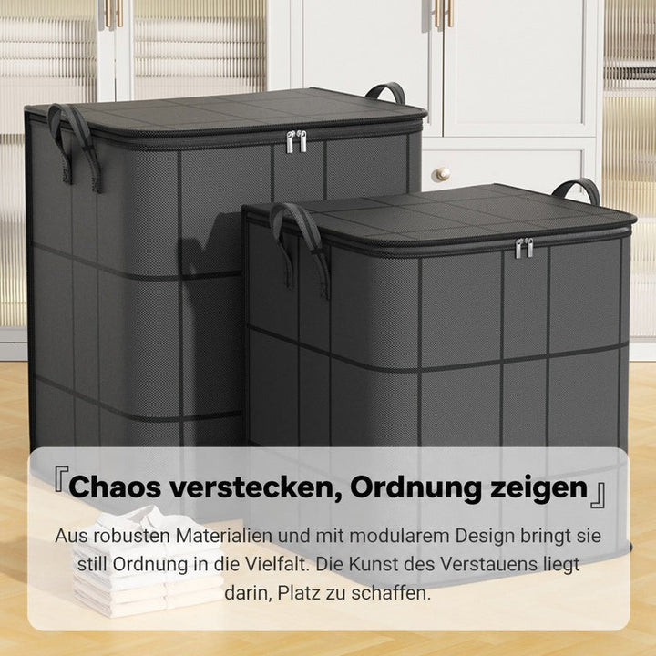 Zwei unterschiedlich große graue Taschen mit Griffen auf Holzboden vor weißem Schrank, davor gefaltete weiße Wäsche. 11
