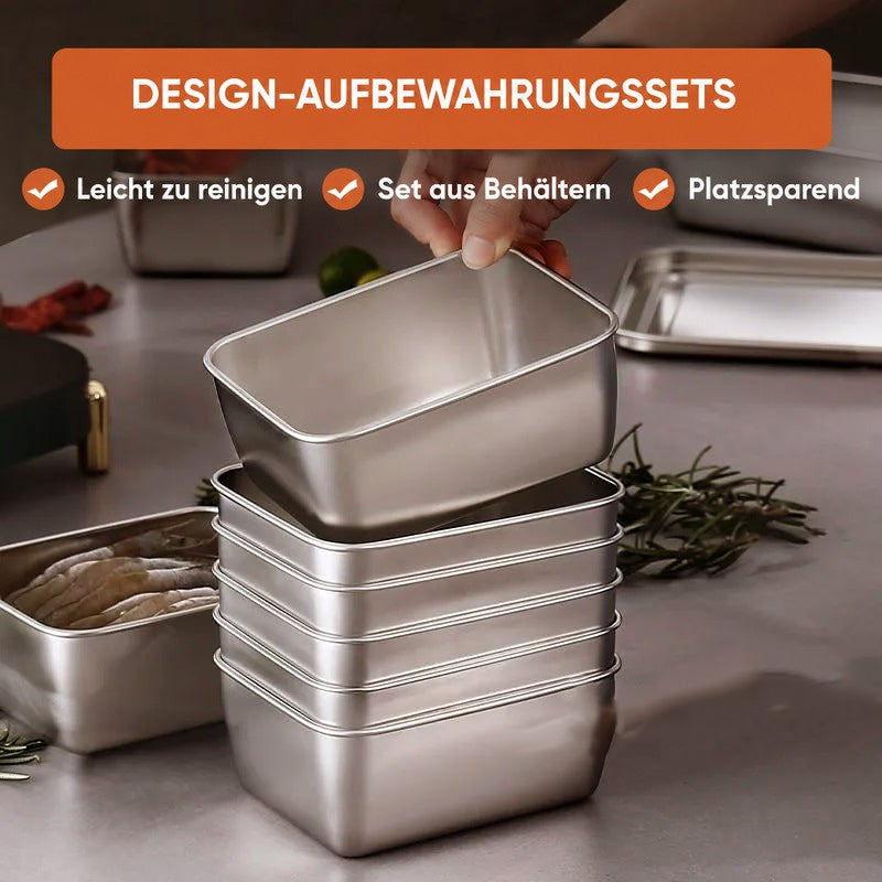 Aufeinander gestapelte Edelstahlboxen auf einer grauen Arbeitsfläche, eine Hand hebt die oberste ab, daneben Rosmarin und eine Box mit Fisch. 4