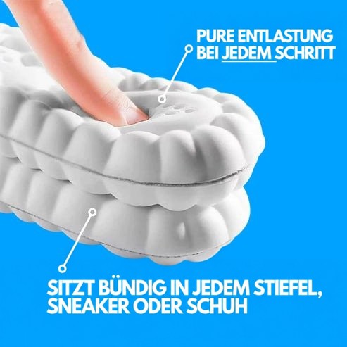 Nahaufnahme einer weißen Einlegesohle, in die ein Finger den weichen Schaum eindrückt, darunter eine zweite Sohle zum Größenvergleich. 5
