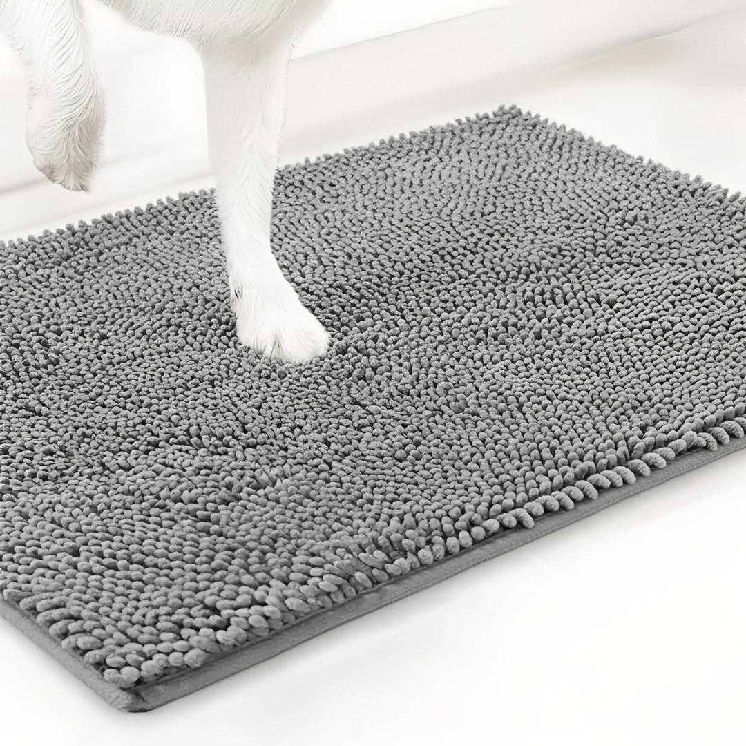 Weiße Hundepfote drückt sich in die graue Chenille-Matte, Schrägansicht der Mattenecke auf weißem Hintergrund. 12