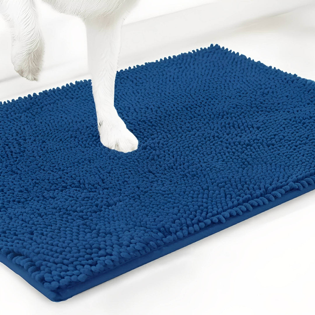 Weiße Hundepfote steht auf der blauen Chenille-Matte, Schrägansicht auf weißem Hintergrund. 17