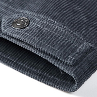 Dunkelgrauer Cordstoff mit Metallknopf, Detailansicht, hochwertige Textur, Modeaccessoire.