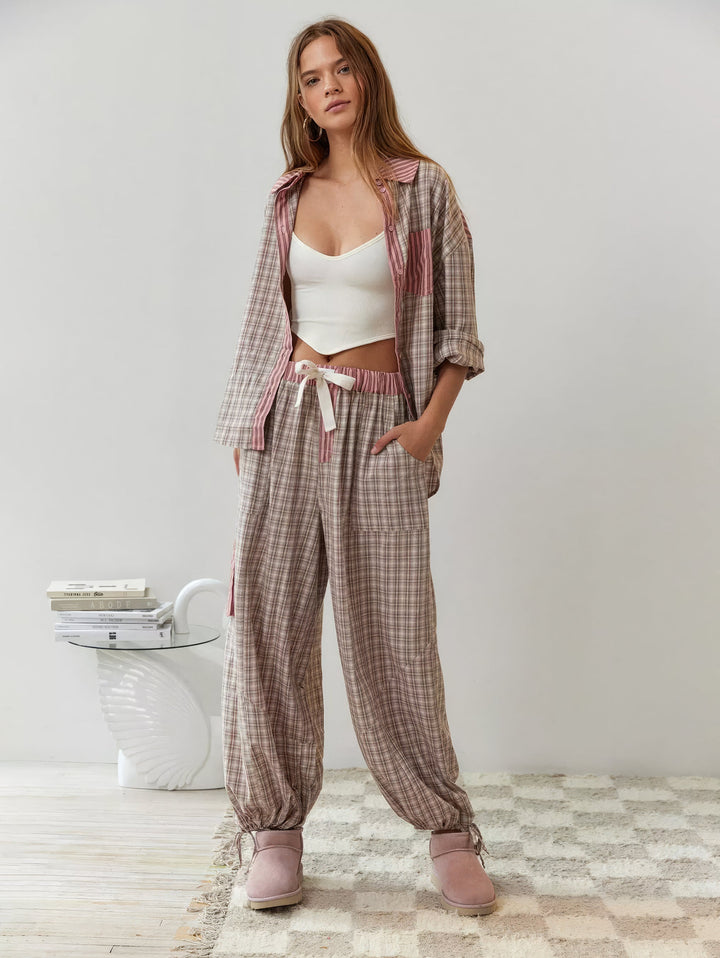 Ganzkörperbild des rosa-beige karierten Sets mit offenem Hemd über weißem Top, Hose mit Kordelzug und Bündchen an den Knöcheln. 6