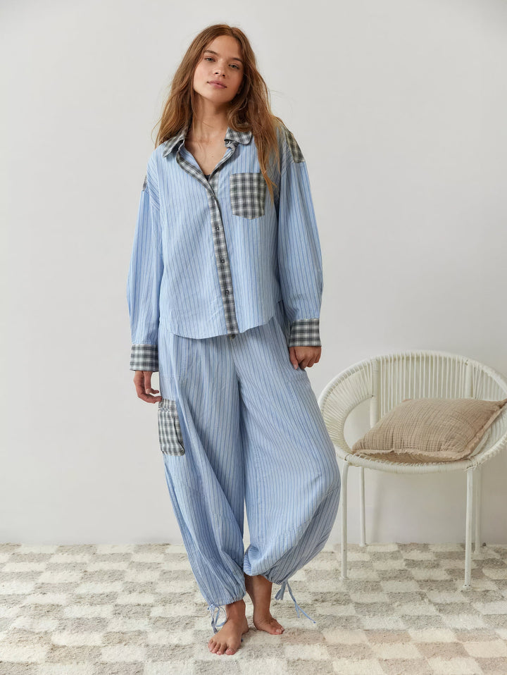 Ganzkörperbild des blau gestreiften Sets barfuß getragen, mit weiter Hose, grau karierter Beintasche und Bindebändern am Saum. 7