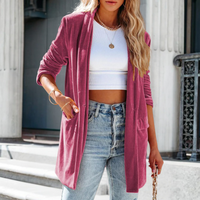 Frau in rotem Cardigan, weißem Top und Jeans vor Gebäude, modisch, lässig, urbaner Stil.