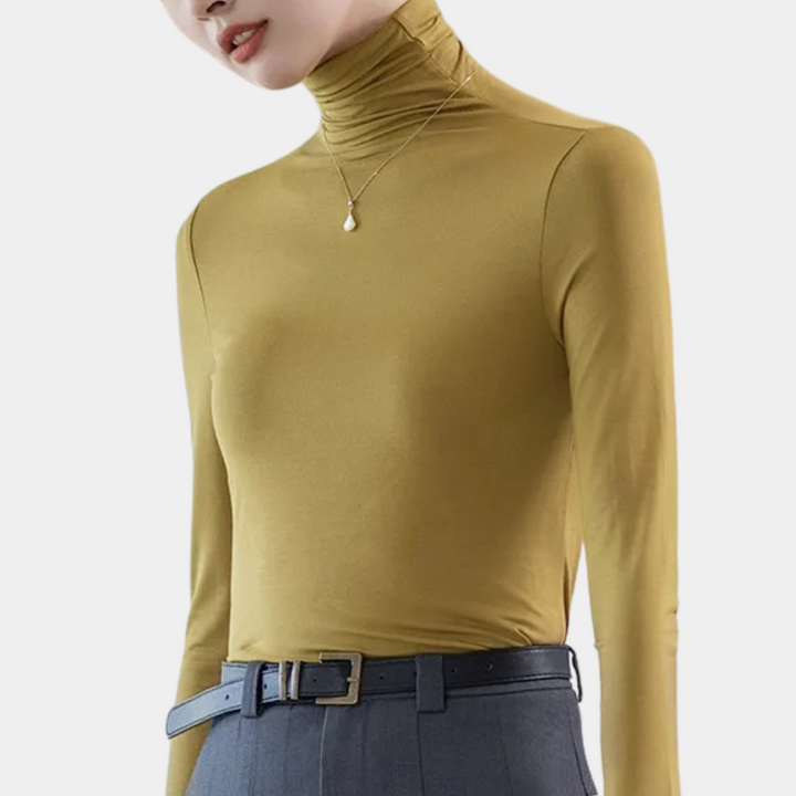 Frau in senfgelbem Rollkragenpullover, graue Hose, goldene Halskette, Mode, Damenbekleidung.
