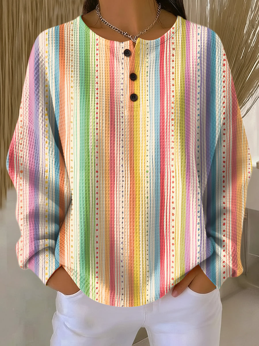 Pullover mit Knopfleiste, getragen, mit bunten vertikalen Regenbogenstreifen und kleinen Punktreihen. 10