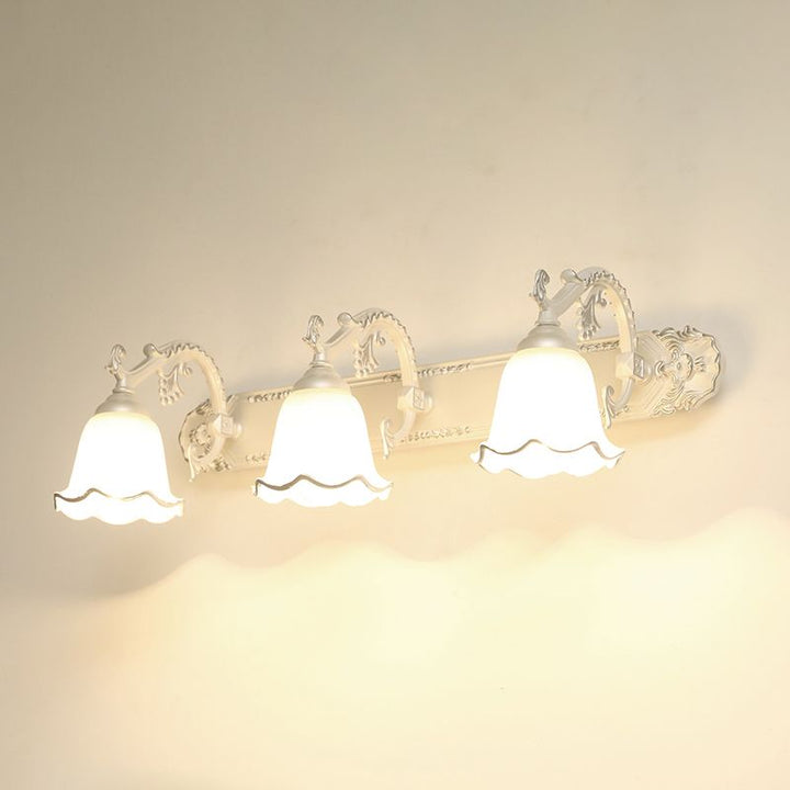 Weiße Vintage-Wandleuchte mit drei Glasschirmen, dekorativ, klassisches Design.