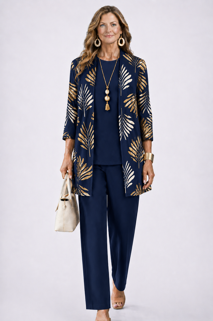 Frau im marineblauen Set, Cardigan mit goldenem Palmblattmuster über einfarbigem Oberteil und Hose, frontal. 7