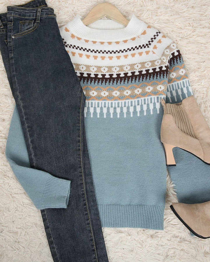 Damen-Winterpullover mit Norwegermuster, blau-weiß, kombiniert mit Jeans und beigen Stiefeletten.