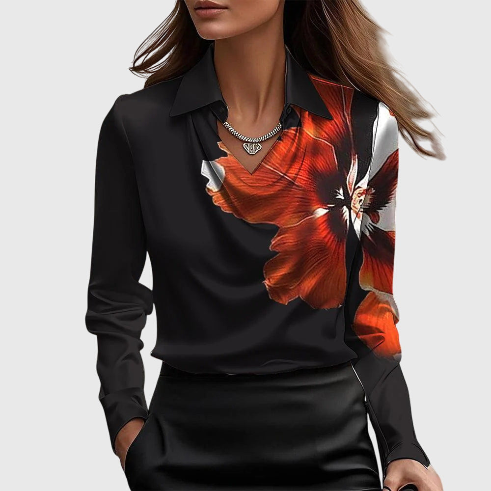 Schwarze Bluse mit großem orangeroten Blütenmotiv an der rechten Seite, Kragen und Wasserfallausschnitt, getragen zum schwarzen Rock. 6