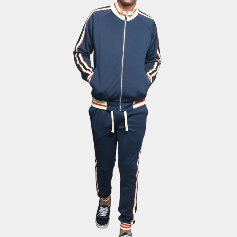 Mann in dunkelblauem Trainingsanzug mit Streifen, Reißverschlussjacke, Freizeithose, Sneakers.