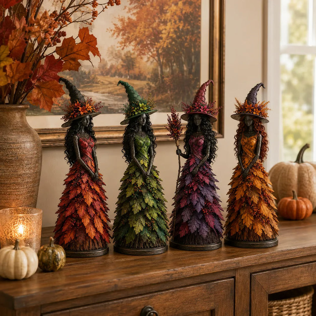 Alle vier Hexenfiguren in Rot, Grün, Violett und Gold in einer Reihe auf einem Holzsideboard mit Kürbissen und Herbstzweigen. 7