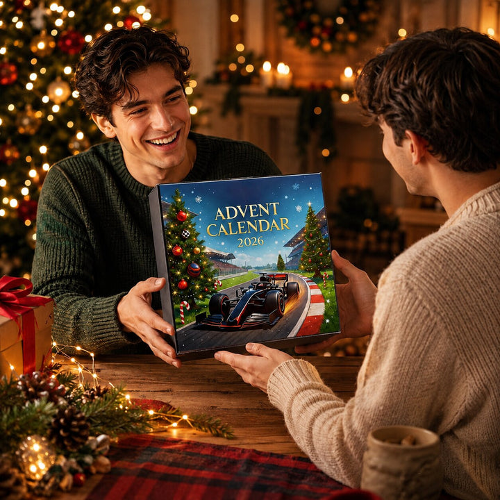 Ein lächelnder Mann überreicht die Kalenderbox als Geschenk an eine zweite Person, beide sitzen am Tisch vor dem Weihnachtsbaum. 7