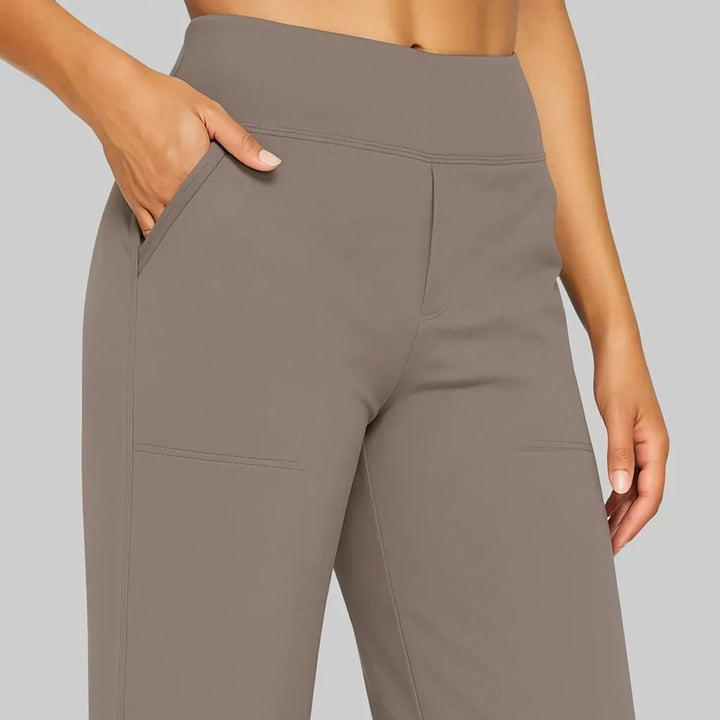 Detailaufnahme von Bund und aufgesetzten Taschen der taupefarbenen Hose, eine Hand steckt in der Seitentasche. 3