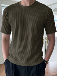 Mann trägt olivgrünes, geripptes T-Shirt, Kurzarm, modern, lässig, Herrenmode.
