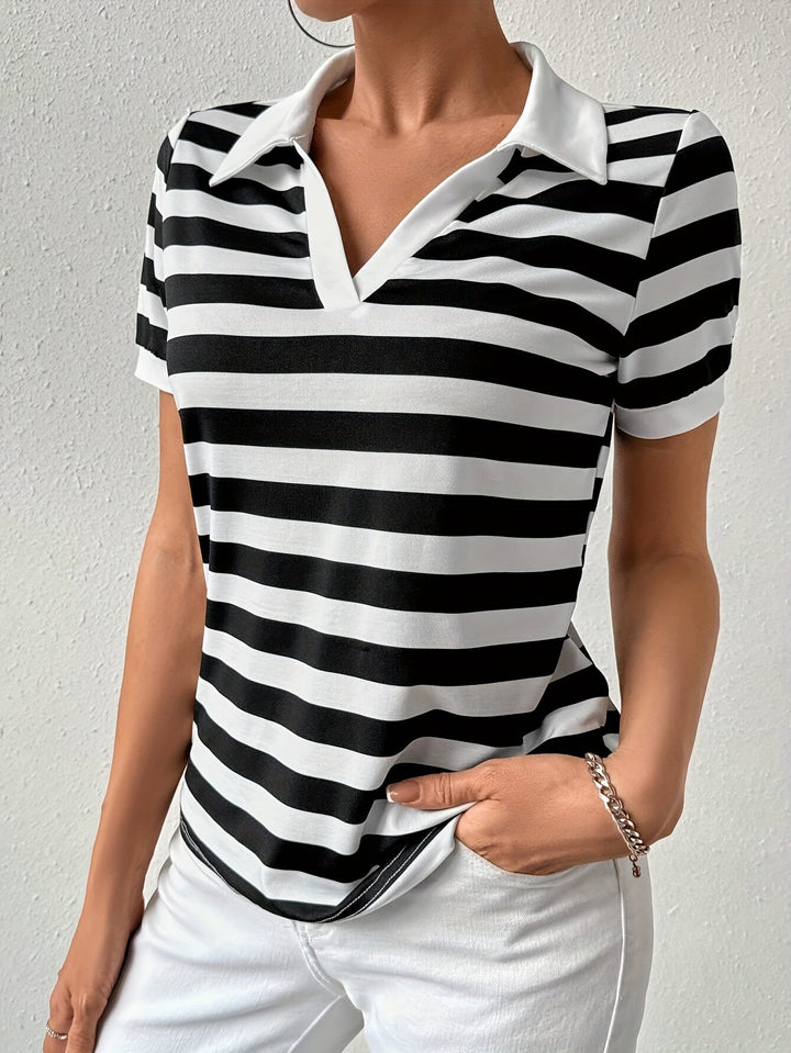 Frau trägt schwarz-weiß gestreiftes Poloshirt, kurzärmelig, mit weißem Kragen, modisch, elegant.
