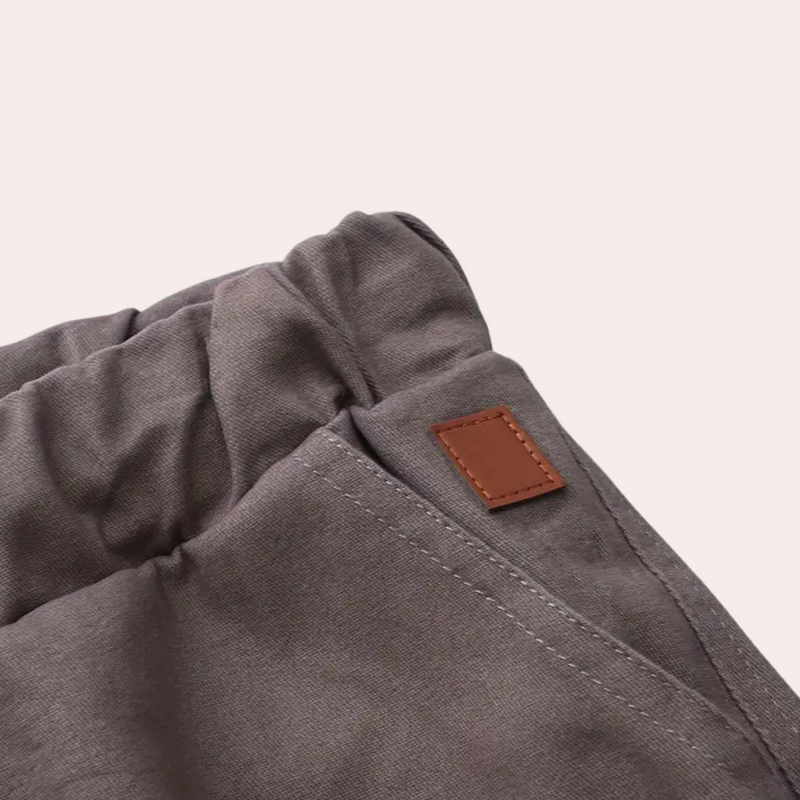 Graue Baumwollhose mit elastischem Bund und braunem Lederetikett, bequeme Freizeitkleidung.