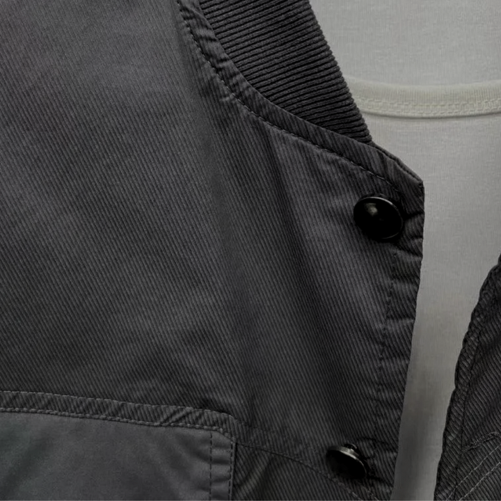 Graue Bomberjacke aus Baumwolle mit schwarzen Knöpfen, Nahaufnahme, modisch, Herrenbekleidung.