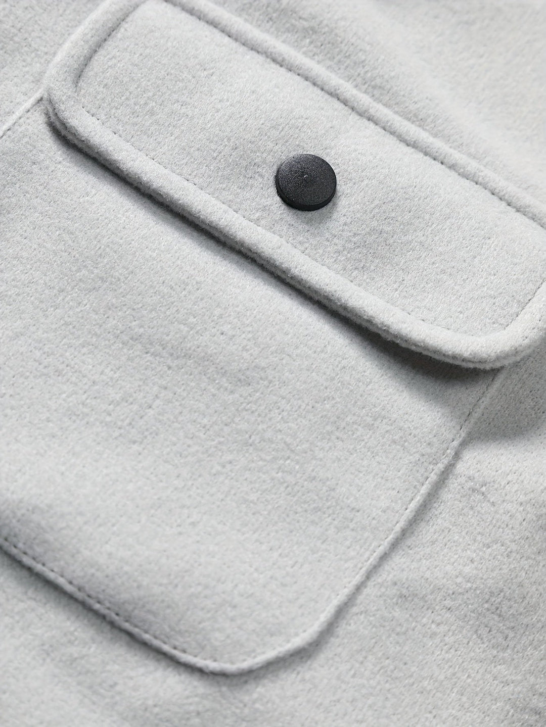 Graue Wolljacke mit schwarzem Knopf und Brusttasche, stilvoll und warm, ideal für Herbstmode.