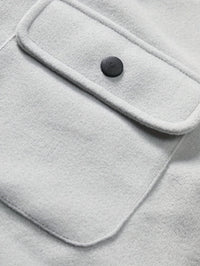 Graue Wolljacke mit schwarzem Knopf und Brusttasche, stilvoll und warm, ideal für Herbstmode.