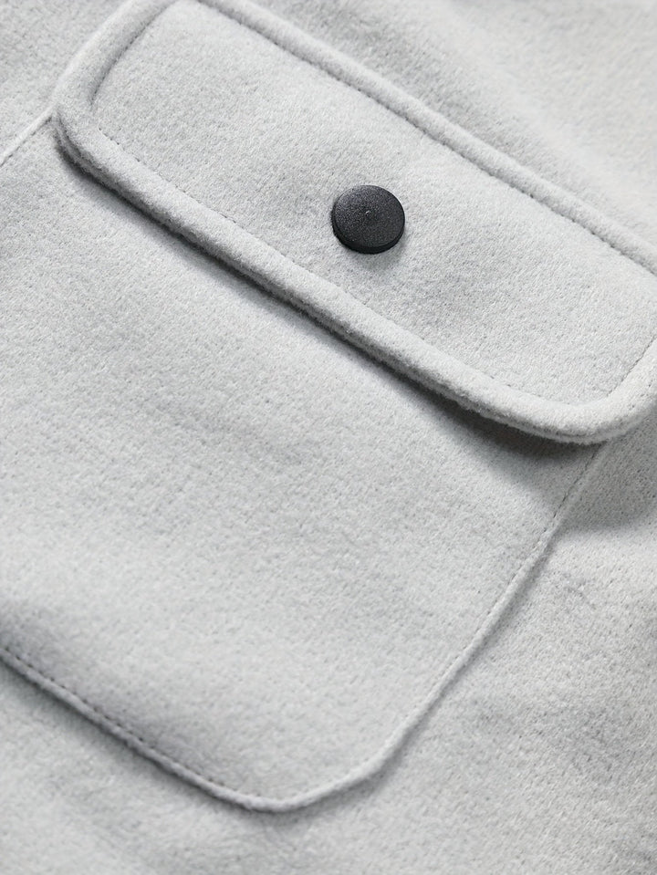 Graue Wolljacke mit schwarzem Knopf und Brusttasche, stilvoll und warm, ideal für Herbstmode.