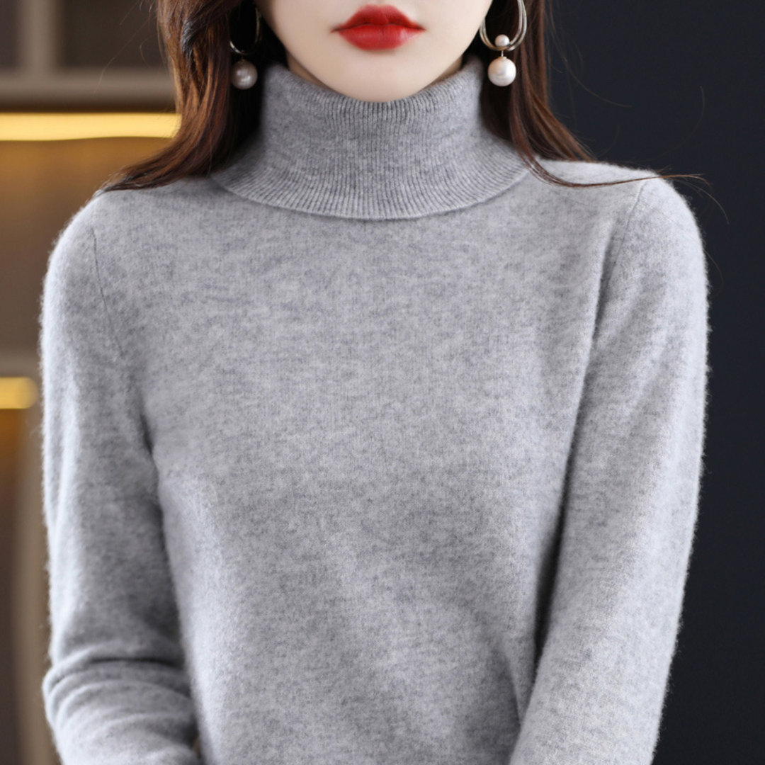 Grauer melierter Rollkragenpullover am Model, Frontansicht mit Blick auf Kragen und Strukturdetails des Strickstoffs. 11