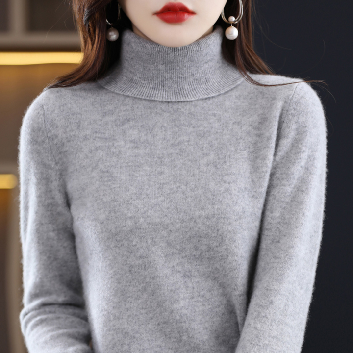Grauer melierter Rollkragenpullover am Model, Frontansicht mit Blick auf Kragen und Strukturdetails des Strickstoffs. 11