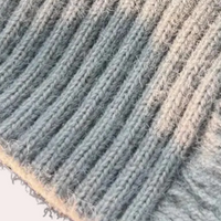 Grauer Strickstoff, Nahaufnahme, weiche Textur, geripptes Muster, hochwertige Wolle.