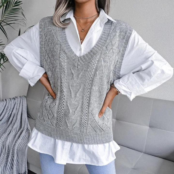Frau trägt grauen Strickpullover über weißer Bluse, modisch, lässig, Herbstmode.