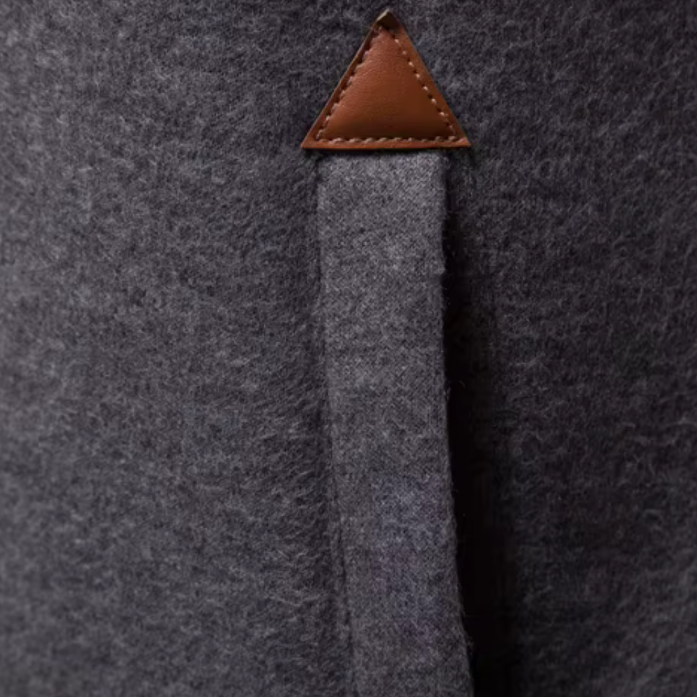 Grauer Wollmantel mit braunem Lederdetail, elegantes Design, hochwertige Wintermode.