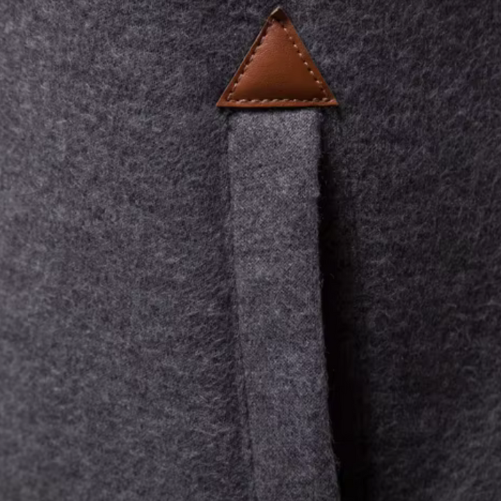 Grauer Wollmantel mit braunem Lederdetail, elegantes Design, hochwertige Wintermode.