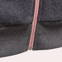 Grauer Wollpullover mit rosa Reißverschluss, weiches Material, modisches Design.