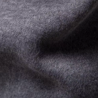 Grauer Wollstoff, Nahaufnahme, weiche Textur, hochwertiges Material, ideal für Bekleidung.