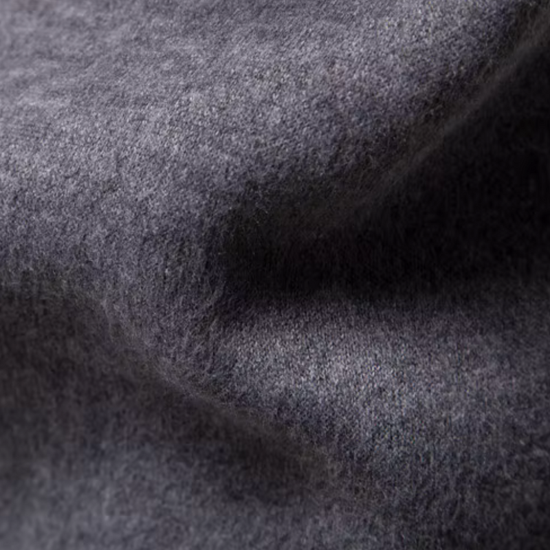 Grauer Wollstoff, Nahaufnahme, weiche Textur, hochwertiges Material, ideal für Bekleidung.