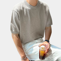 Graues T-Shirt aus Baumwolle, kurzärmelig, lässig, Mann hält Eiskaffee, Sommermode.