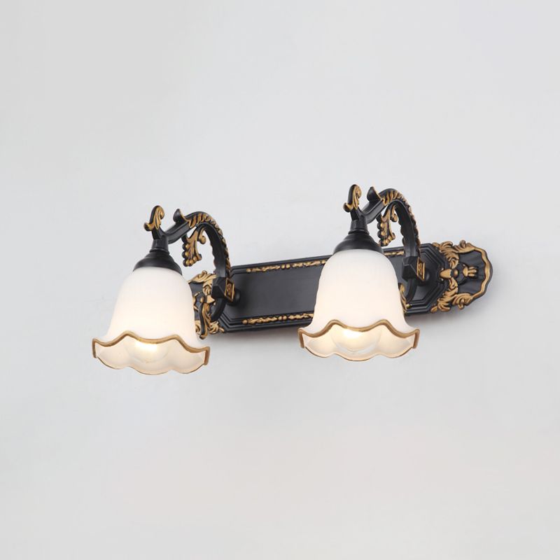 Schwarze Wandleuchte mit zwei weißen, goldverzierten Lampenschirmen im Vintage-Stil.