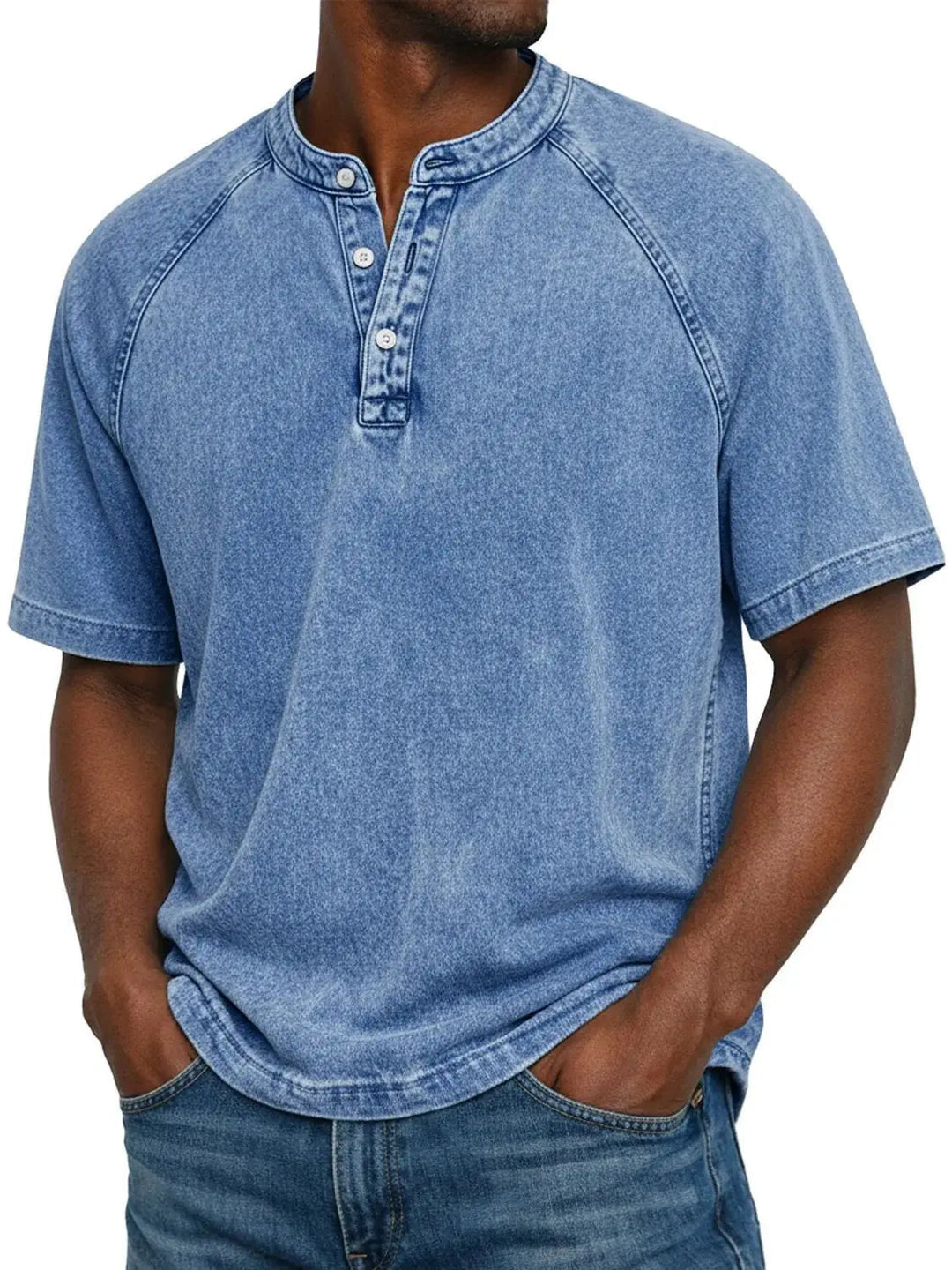 Mann trägt das Henley-Shirt mit Raglanärmeln in verwaschenem Hellblau, kombiniert mit Jeans, Frontansicht. 2