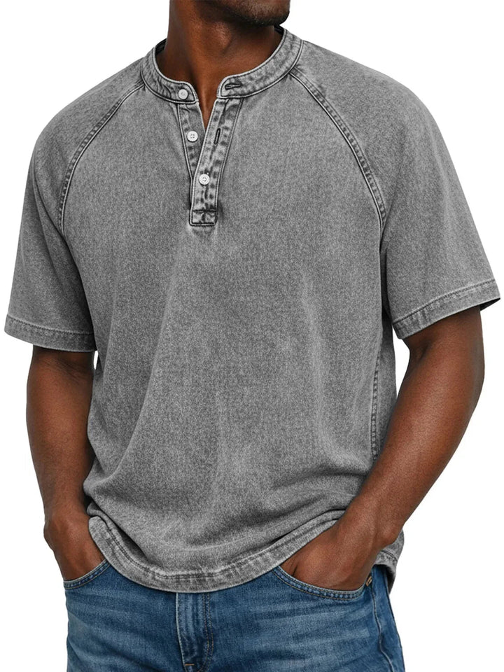 Mann trägt das Henley-Shirt mit Raglanärmeln in verwaschenem Grau, Knopfleiste am Rundhals, dazu Jeans, Frontansicht. 4