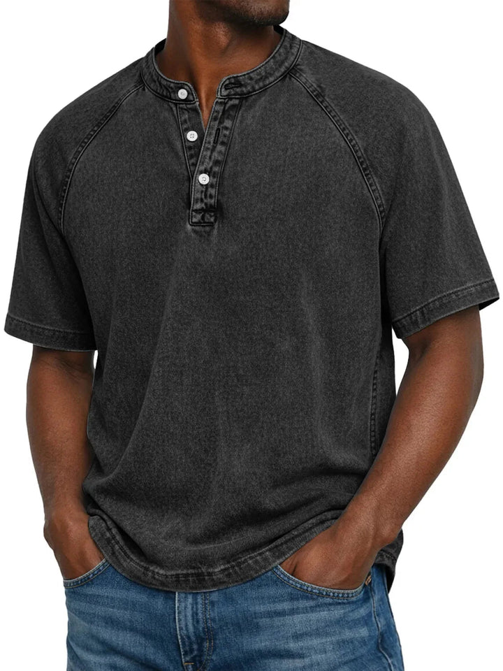 Mann trägt das Henley-Shirt mit Raglanärmeln in verwaschenem Schwarz mit heller Naht, Frontansicht mit Jeans. 5