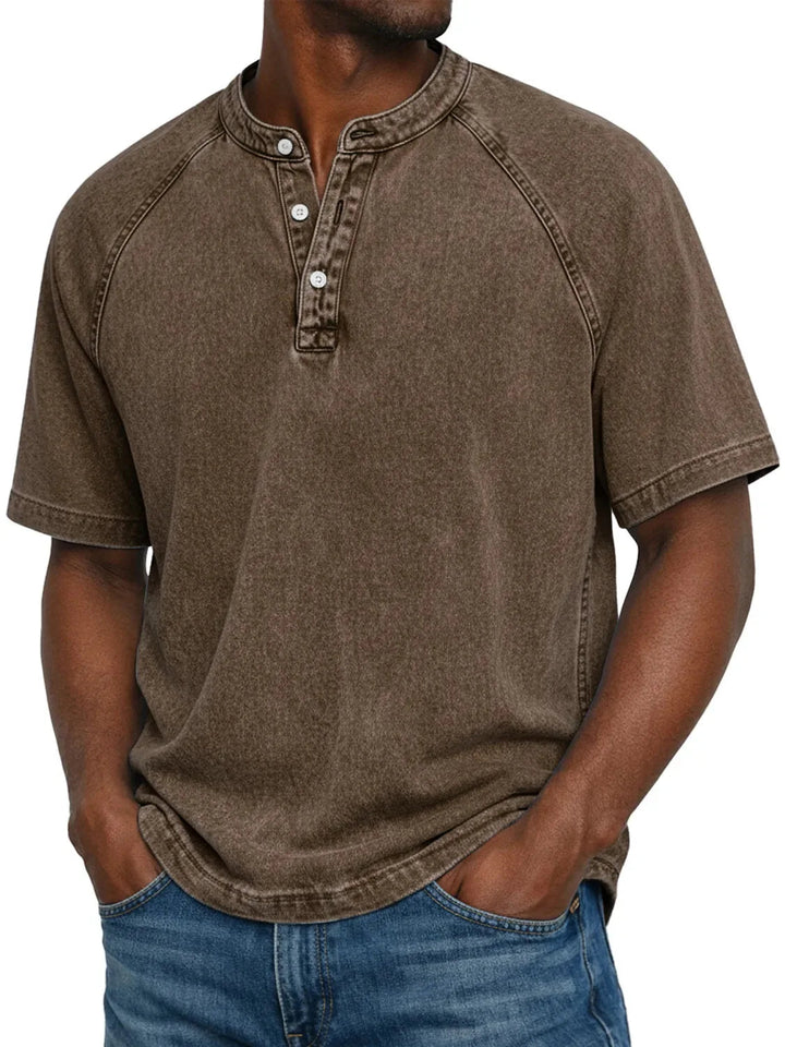 Mann trägt das Henley-Shirt mit Raglanärmeln in verwaschenem Braun, mit Knopfleiste und Jeans, Frontansicht. 8
