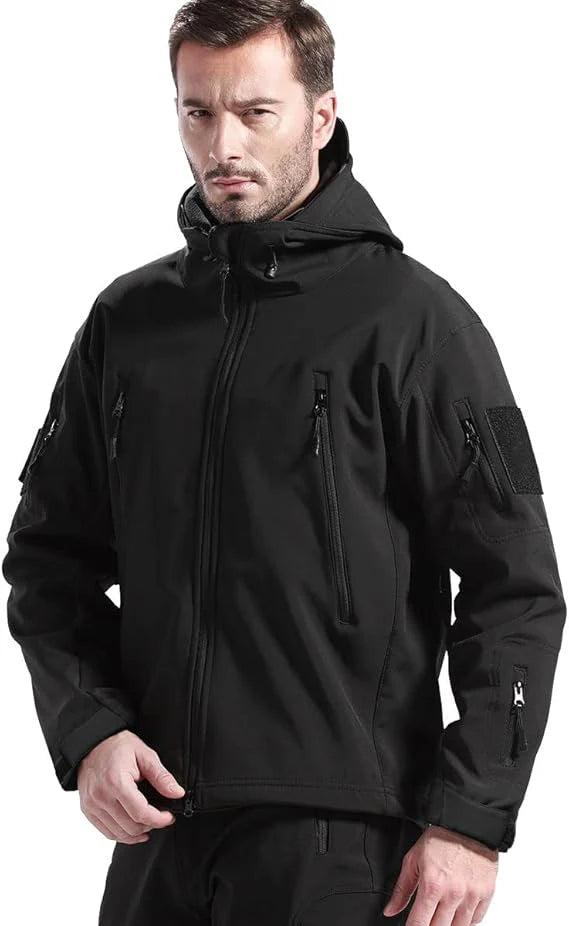 Mann mit Bart trägt die schwarze Kapuzenjacke, geschlossen, mit Brusttaschen und Klettfläche am Oberarm, Blick in die Kamera. 8