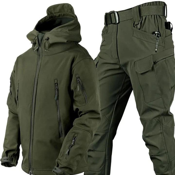 Outdoorset in Olivgrün: Kapuzenjacke mit Reißverschlusstaschen und Cargohose mit Gürtel und aufgesetzten Taschen, nebeneinander freigestellt. 1