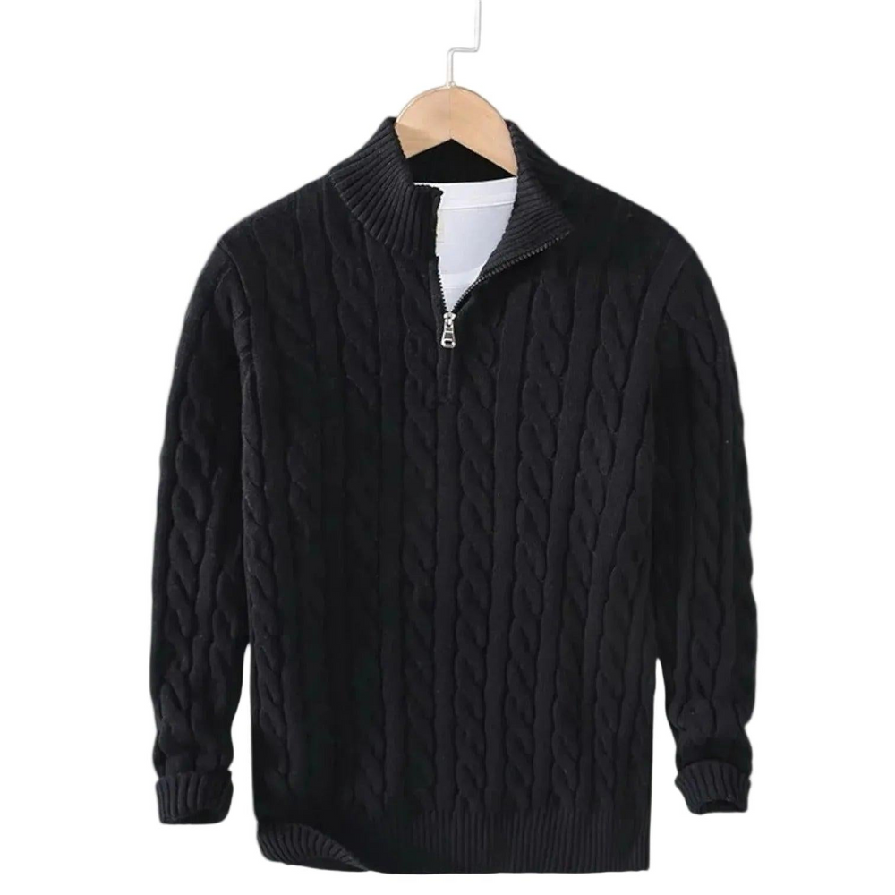 Schwarzer Zopfstrick-Pullover mit Stehkragen und kurzem Reißverschluss auf einem Holzbügel hängend, darunter ein weißes Shirt. 2