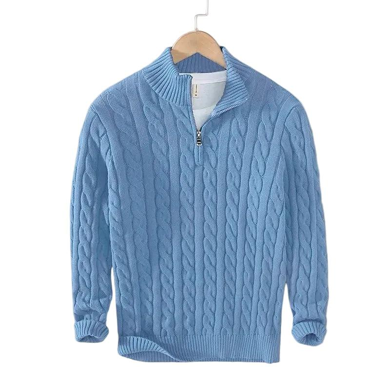 Hellblauer Zopfstrick-Pullover mit Stehkragen und Halbreißverschluss, auf einem Bügel hängend, mit weißem Shirt darunter. 3