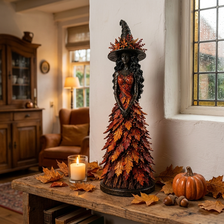 Hexenfigur mit Spitzhut und rot-orangem Blätterkleid auf einer rustikalen Holzbank neben Kerze, Kürbis, Eicheln und Herbstlaub in einem Wohnzimmer. 1