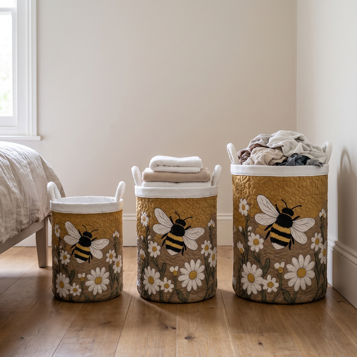 Drei Körbe in unterschiedlichen Größen mit Bienenmotiv und weißem Rand stehen nebeneinander im Schlafzimmer, gefüllt mit Handtüchern und Wäsche. 4