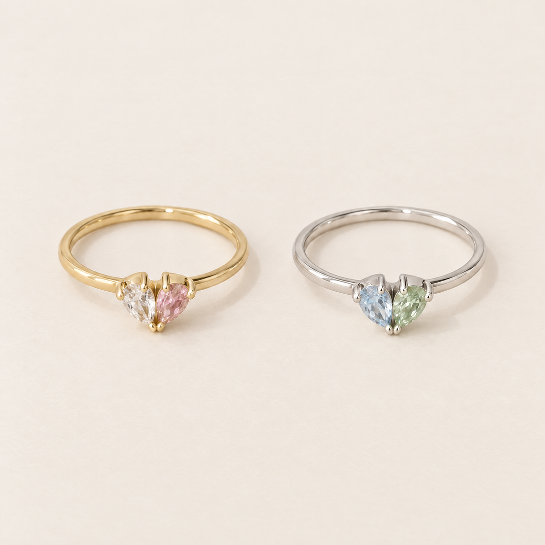 Zwei Ringe nebeneinander: links goldfarben mit klarem und rosafarbenem Stein, rechts silberfarben mit blauem und grünem Stein. 4