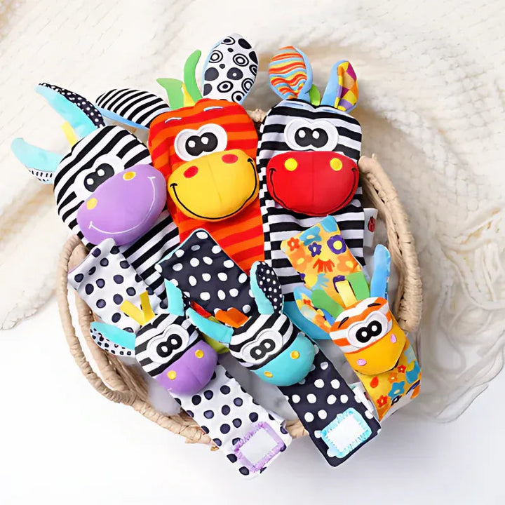 Geflochtener Korb voller Rasselsocken und Handgelenkrasseln mit Tiergesichtern in Schwarz-Weiß, Orange, Lila und Türkis, teils mit Punktmuster. 9